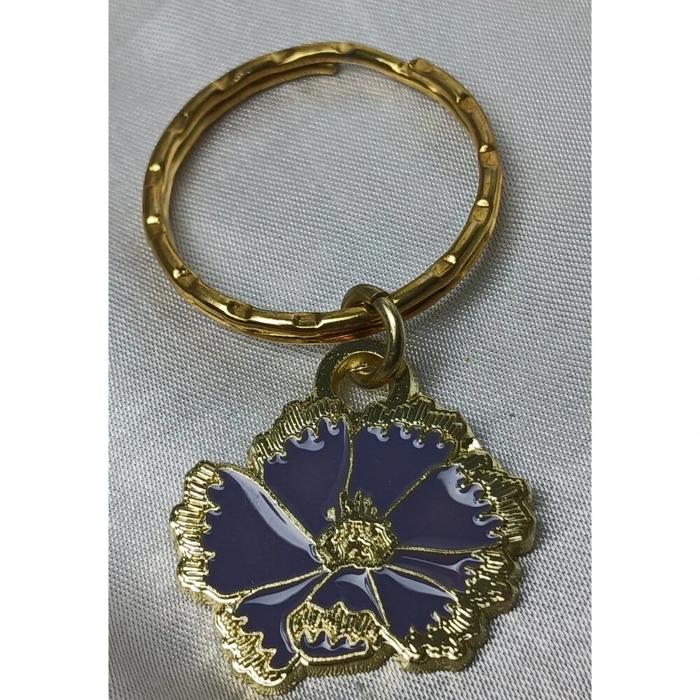 LES CHAPEAUX DANS LE JARDIN (HATS IN THE GARDEN) 2024 PURPLE FLOWER KEYCHAIN